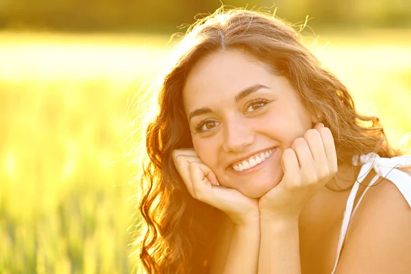 幸せな女性笑顔で完璧な歯でポーズでフィールドで日没 — ストック写真