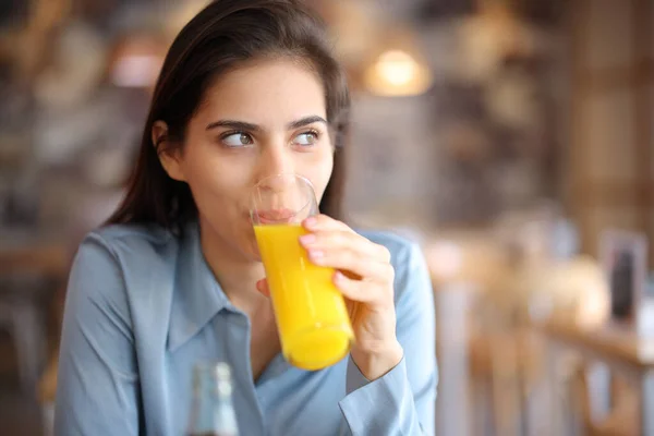 Vrouw Afgeleid Kijkend Naar Kant Drinken Sinaasappelsap Een Bar Interieur — Stockfoto