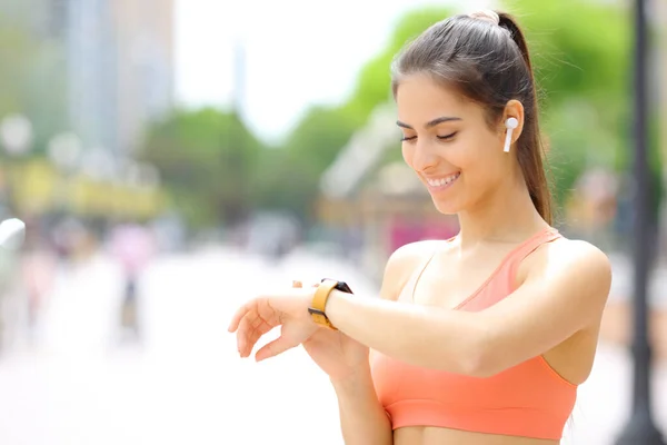 Happy Runner Wearing Earbud Selecting Music Smartwatch Run Street — Stock Photo, Image