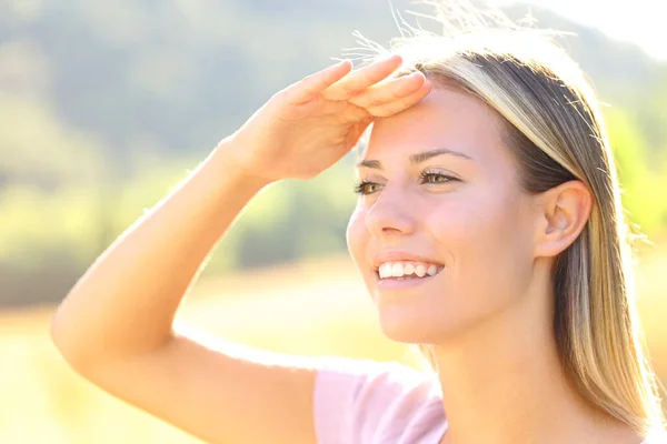 太陽から自然の中で保護額に手で幸せな女性 — ストック写真