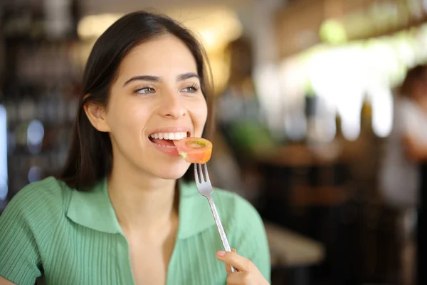 Mulher Feliz Comendo Tomate Restaurante Interior Olhando Para Longe — Fotografia de Stock