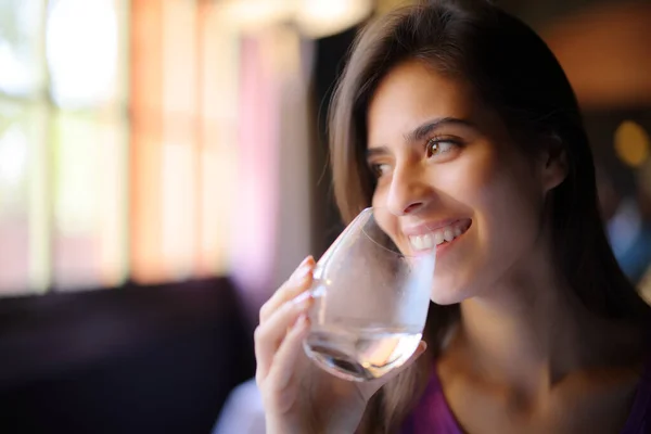 Szczęśliwa Kobieta Pije Wodę Przezroczystego Szkła Patrzy Bok Restauracji — Zdjęcie stockowe