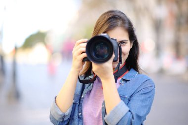 Fotoğrafçı, sokakta bir DSR ile senin fotoğraflarını çekiyor.