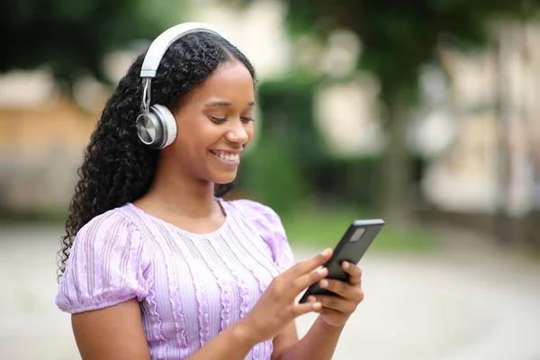 Szczęśliwy Czarny Kobieta Słuchawki Sprawdzanie Muzyki Telefon Waling Ulicy — Zdjęcie stockowe