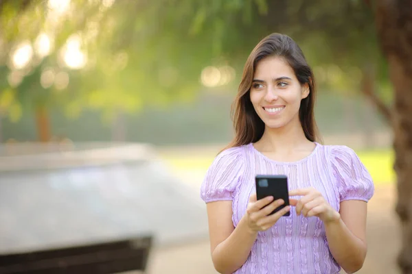 Widok Przodu Portret Szczęśliwej Kobiety Korzystającej Telefonu Patrząc Boczne Chodzenie — Zdjęcie stockowe