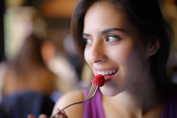 快乐的女人一边吃黑莓一边看着旁边坐在餐馆里 — 图库照片