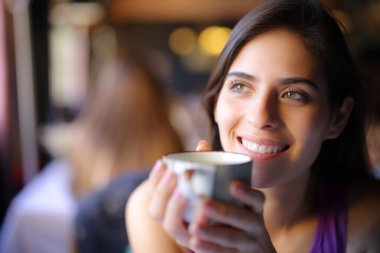 Bir restoranın içinde kahve içen mutlu bir hayalperest.