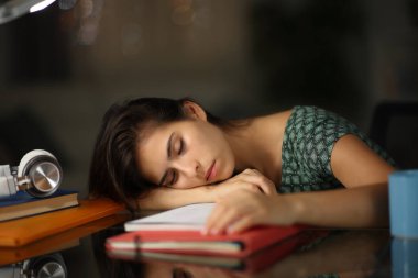 Yorgun öğrenci gece evde notlarda uyuyakalıyor.