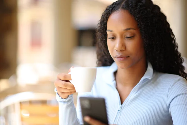 Черная Женщина Пьет Кофе Проверяя Телефон Террасе Ресторана — стоковое фото