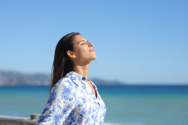 Side view portrait of a woman breathing and relaxing on the beach