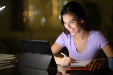 Mutlu öğrenci gece geç saatte evde e-posta kullanarak öğreniyor.