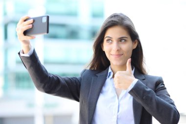 Yönetici sokakta tek başına selfie çekiyor.