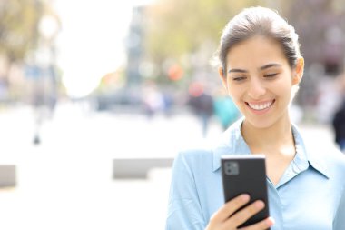 Sokakta fotokopi alanı olan telefonu kullanan mutlu bir iş kadını portresi.