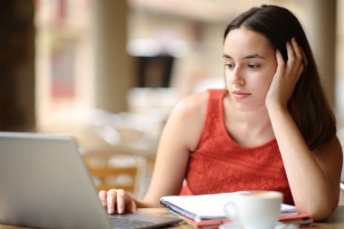 Öğrenci bir kafede bilgisayar kullanarak e-öğreniyor.