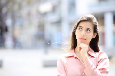 Elinde fotokopi aletiyle caddenin kenarına bakan şüpheli düşünceli bir kadının portresi.