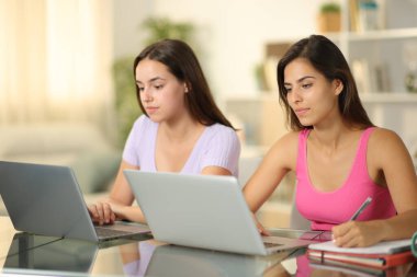 İki öğrenci evde birlikte ders çalışıyor.