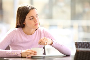 Kafası karışmış bir kadın, bardan başka bir yere bakıyor.