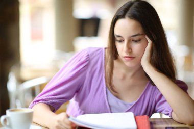 Ciddi öğrenci notları okuyup bar terasında oturarak öğreniyor.