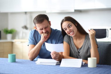 Kızgın çift mutfaktaki faturaları kontrol etmekte zorlanıyor.