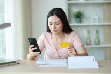 Ciddi Asyalı kadın internet üzerinden telefon ve kredi kartıyla faturaları ödüyor.