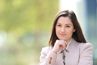 Kendine güvenen yönetici caddede duran kameraya bakar.