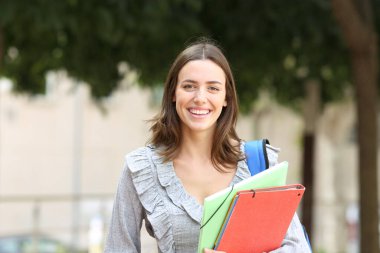 Sokakta poz veren mutlu bir öğrencinin portresi.