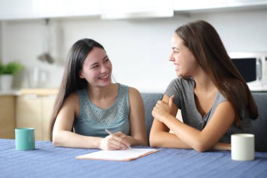 Mutlu ırklar arası kadınlar evdeki mutfakta sözleşmeden bahsediyorlar.