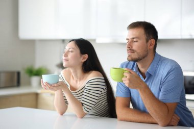 Evdeki mutfakta içen ve nefes alan ırklar arası bir çift.