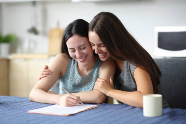 Mutlu ırklar arası çiftler evdeki mutfakta kucaklaşıp kontrat imzalıyorlar.