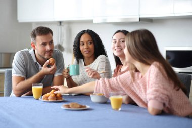 Kahvaltıdaki ırklar arası arkadaşlar mutfakta konuşuyorlar.