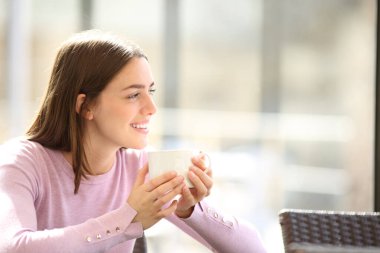 Lokantada oturup kahve içen mutlu kadın gözlerini kaçırıyor.