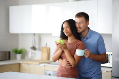 Irklar arası içki içen çift evdeki mutfaktan uzağa bakıyor.