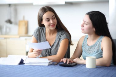 Irklar arası oda arkadaşları mutfaktaki banka hesaplarını kontrol ediyor.