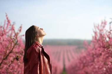 Kırmızılı, temiz hava soluyan bir kadının profili.