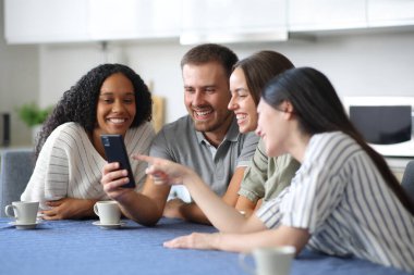Dört mutlu ırklar arası arkadaş evdeki mutfakta telefon içeriği hakkında konuşuyorlar.