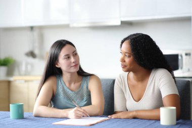 Ciddi ırklar arası oda arkadaşları evdeki mutfakta sözleşmeden bahsediyorlar.