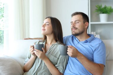 Kahve kokan bir çift evdeki kanepede oturup dinleniyor.