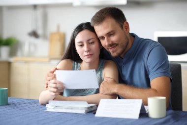 Tatmin olmuş ırklar arası aşk evdeki mutfakta mektupları kontrol ediyor.