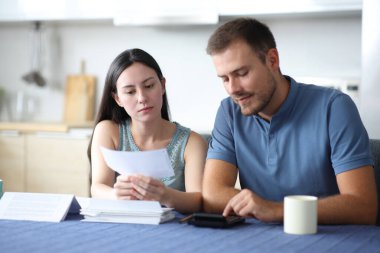 Irklar arası çiftler, mutfaktaki faturaları hesaplıyor.