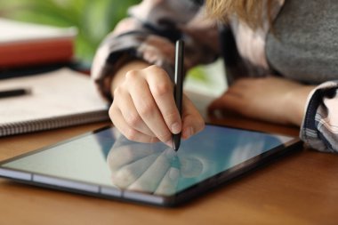 Tablete yazmak için dijital kalem kullanan bir öğrencinin portresini kapat