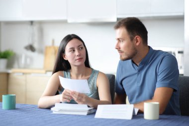 Ciddi bir ırklar arası çift mutfaktaki banka hesap özeti hakkında konuşuyor.