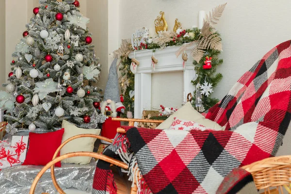リビングルームで赤い再生とクッションとロッキングチェア クリスマスツリーを飾りました 木製の丸太と偽の暖炉 靴下をぶら下げ — ストック写真