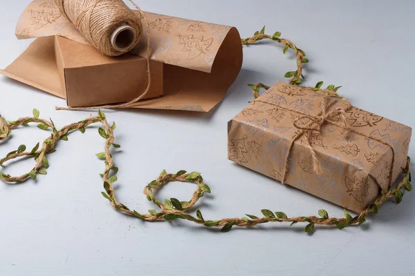 圣诞礼物包装 白色桌子上的黄麻绳线轴等天然土色纸和环保装饰元素 — 图库照片