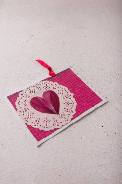 14 Şubat Sevgililer Günü kartpostalında pembe kalp resmi var.