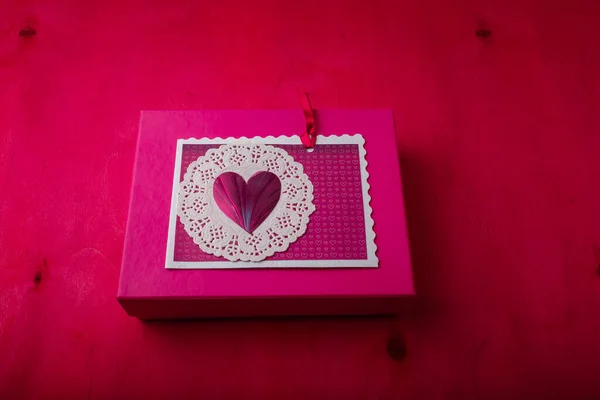 明るいピンクのプレゼントボックス 絵の木製の背景に心を持つポストカード ハッピーセイントバレンタインデー コピースペース — ストック写真