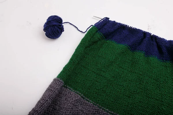 編んだ服 作る過程でアクセサリー 針と糸のボールを編む 白い背景に糸 灰色の布を縞 — ストック写真