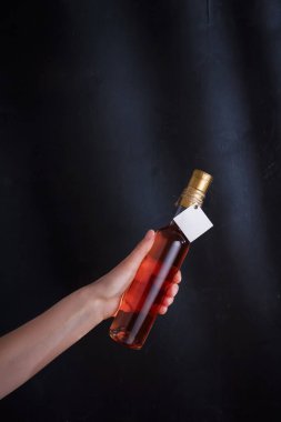 Üzerinde şablon etiketi olan pembe şarap şişesi, markasız. Riesling, chardonnay, sauvignon blanc. Siyah arkaplanda alkol içeceği