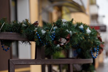 Noel için yeşil süslemeli korkuluklar, mavi boncuklar ve köknar konileri, Yeni Yıl kutlamaları