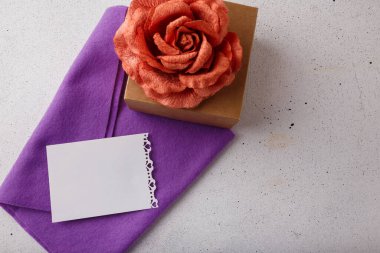 Kahverengi karton hediye kutusu, kumaş gül çiçeği, beyaz arka planda boş kartpostal. Sevgililer günü, doğum günü ya da düğün sürprizi