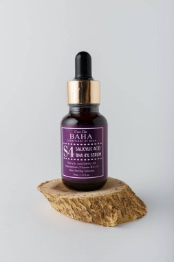 Izmail, Ukraine. March 2022. Baha cosmetics. Bottle of salicylic acid on wooden cut on white background. Face skin care, copy space